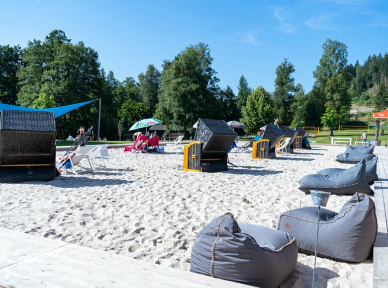Eine große Sandfläche mit Strandkörben und Sitzsäcken lädt zum Verweilen ein. 