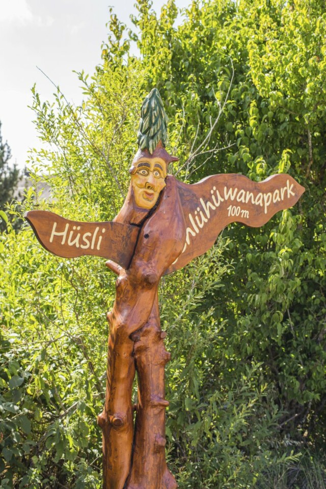 Holzfigur zeigt die Richtung zum Schlühüwanapark